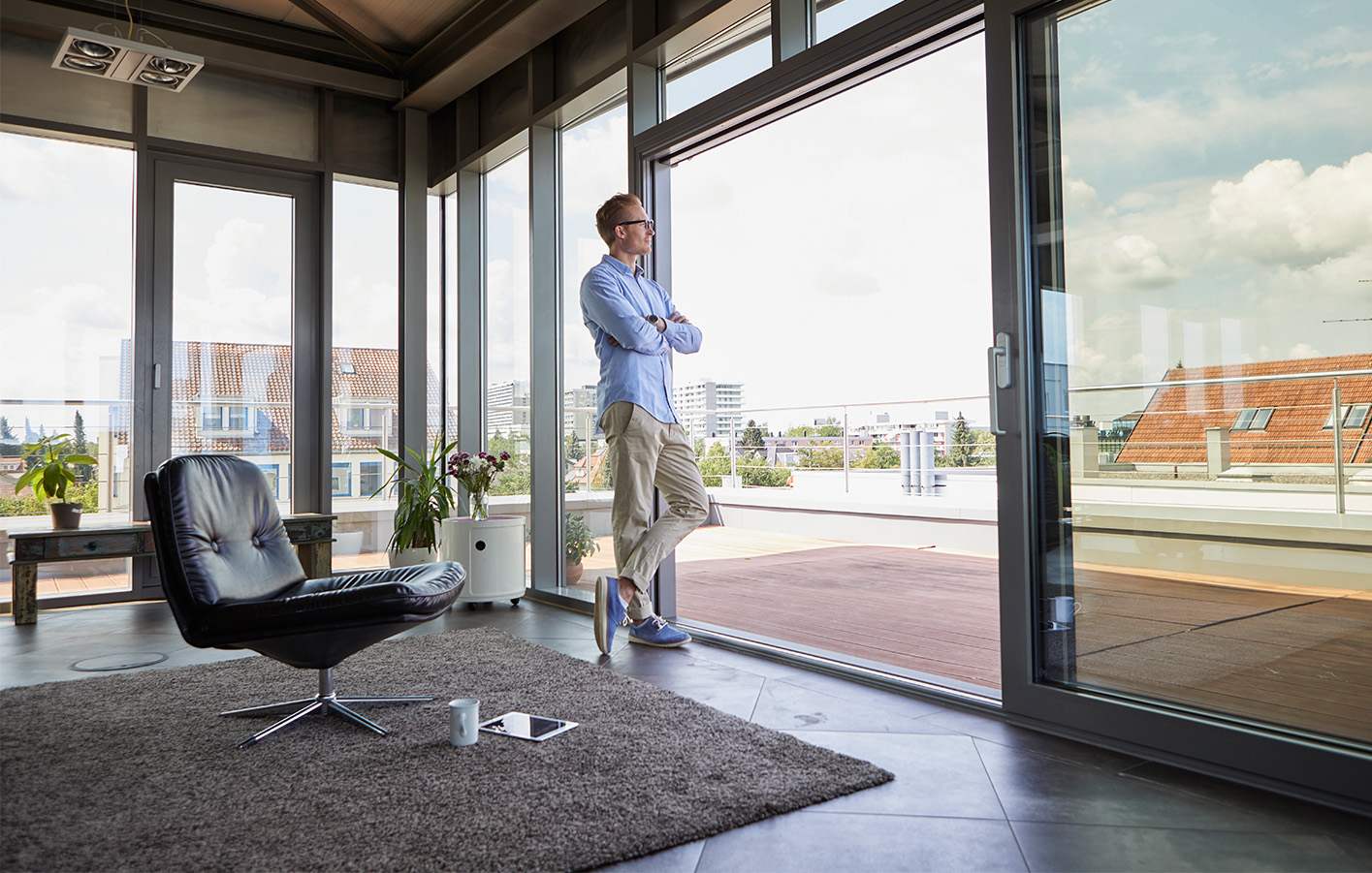 Modernes Büro mit Panorama-Fenstern Mann steht in einem Büro vor einer großen Fensterfront mit Blick auf die Stadt.